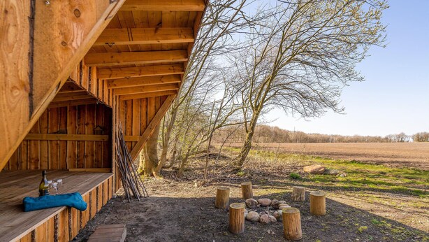 A rustic wooden building with a wooden bench and a bottle of wine. - 3 bedroom beautiful apartment in Kibæk (Kibæk)