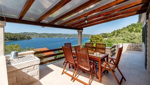 A covered outdoor dining area with a view of a lake and boats. - 3 bedroom lovely home in Vela luka (Vela luka)