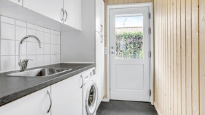 Una cocina moderna con un lavamanos, lavavajillas y una puerta que da a un balcón.