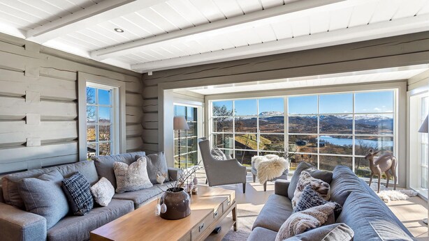 A spacious living room with a large window offering a scenic view of mountains and a lake. - Beautiful home in Rauland with sauna (Rauland)