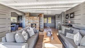 A spacious living room with a stone fireplace, grey sofas, and a wooden coffee table. - Beautiful home in Rauland with sauna (Rauland)