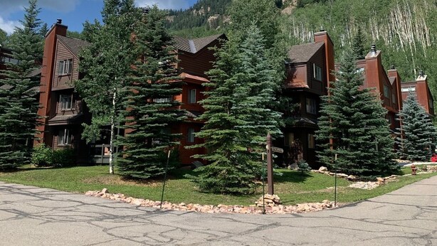 A row of red-roofed buildings with a mountain backdrop.