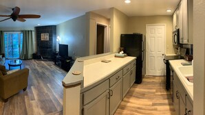 A modern kitchen with a central island, a dining area with a sofa, and a fireplace.