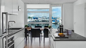Eine moderne Küche mit Blick auf Boote durch ein großes Fenster.