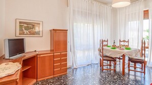 A dining area with a table set for two, a television, and a cabinet. - Awesome apartment in Viareggio with WiFi (Viareggio)