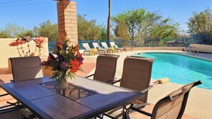 An outdoor pool area with lounge chairs and a table with chairs. - Close to downtown but feels like country-Very Private! Refreshing pool & hot tub (Tucson)