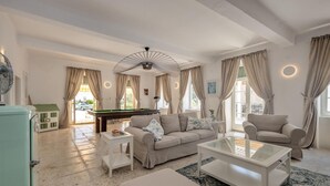 A spacious living room with a pool table, a sofa, a coffee table, and a ceiling fan. - Beautiful home in Jadranovo (Jadranovo)