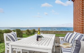 Enjoy a casual meal or wine tasting on this ocean-view patio with a table for two and comfortable seating.