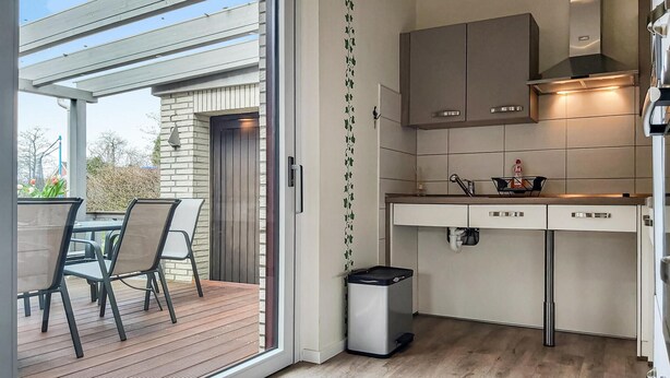 A modern kitchen with white cabinets, a stainless steel range hood, and a small trash bin. - 5 bedroom amazing home in Wurster Nordseeküste (Wurster Nordseeküste)