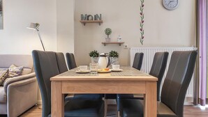 A dining area with a wooden table, black chairs, a coffee pot, cups, and a clock on the wall. - 5 bedroom amazing home in Wurster Nordseeküste (Wurster Nordseeküste)