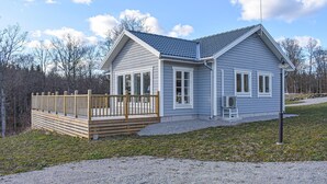 A single-story house with a covered porch, a satellite dish, and a gravel driveway.