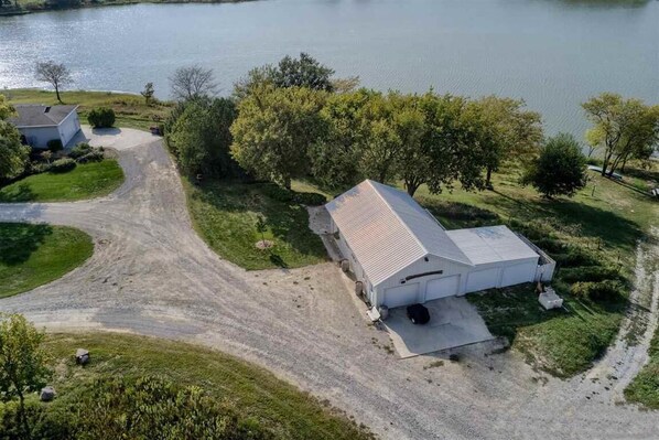 An aerial view of a property with a large building, a dirt road, and a body of water. - Vineyard Cottage (Crab Orchard)