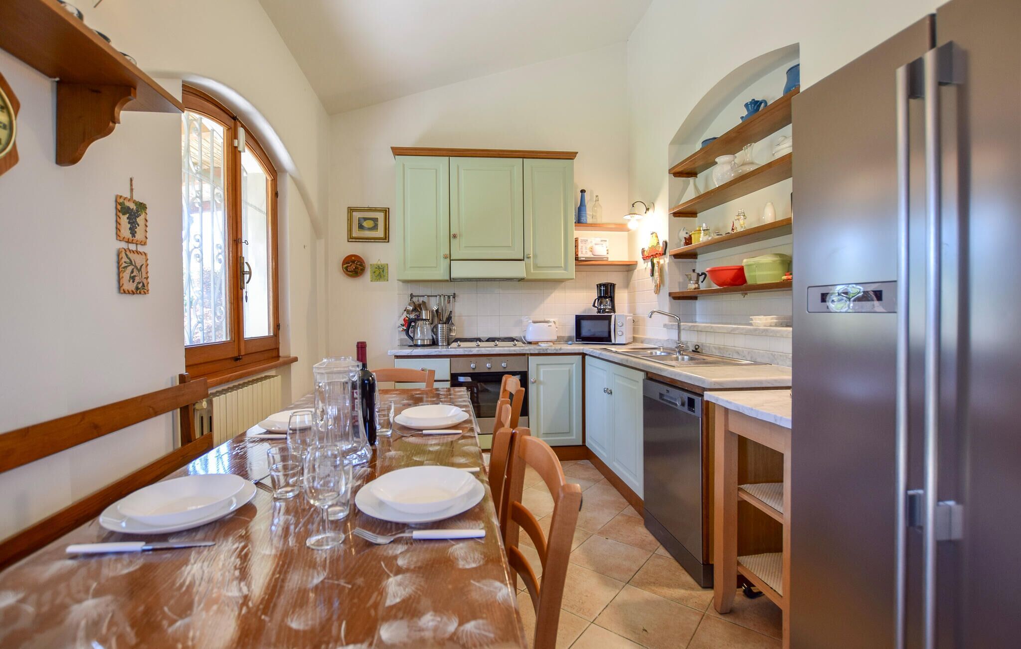 Une cuisine équipée d’une table à manger pour quatre personnes, d’un réfrigérateur et d’un four à micro-ondes.