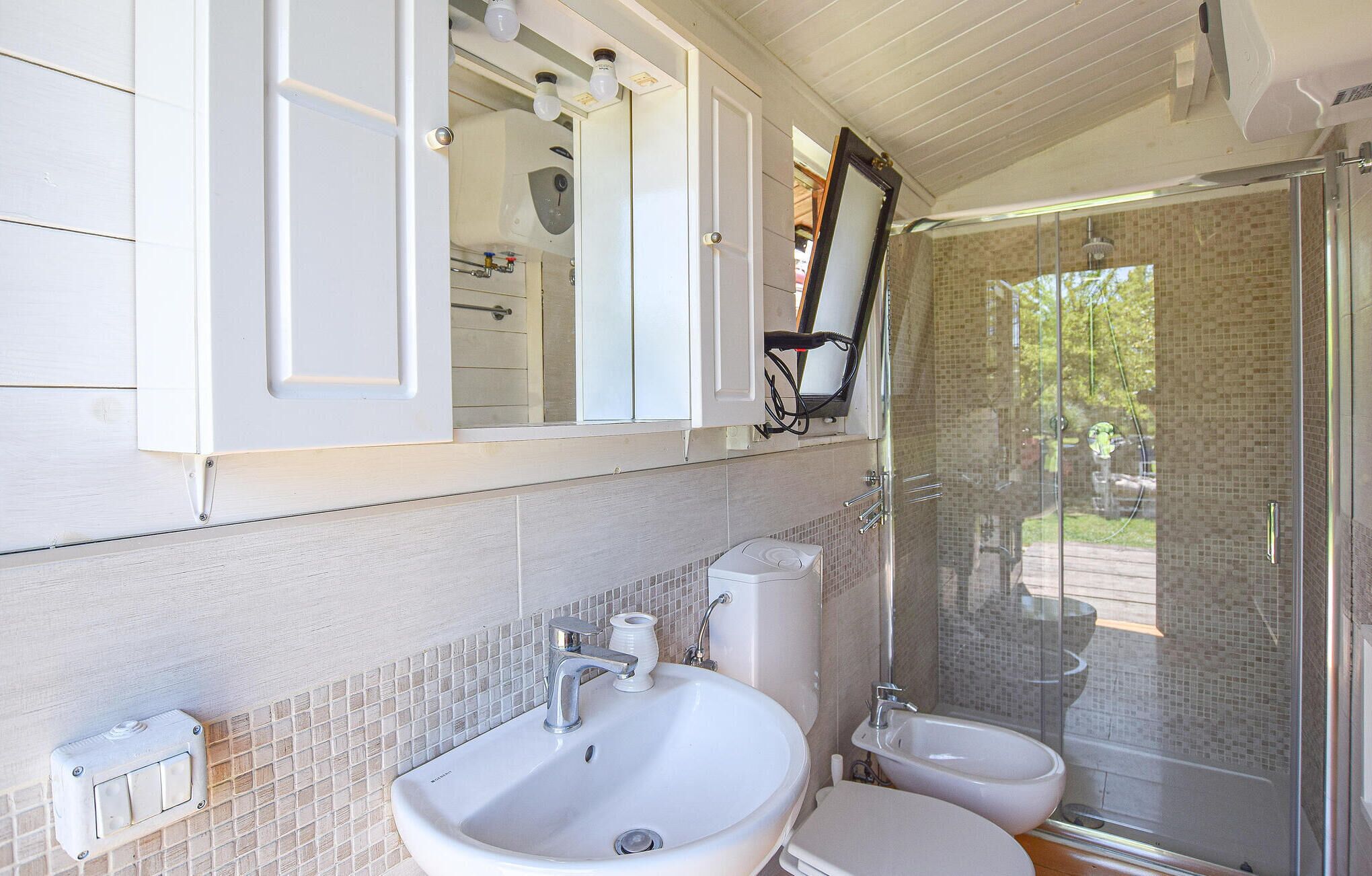 A bathroom with a large sink, a bidet, and a glass-enclosed shower.
