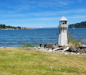 A lighthouse by a lake with clear skies.