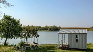 A lakeside cabin with a dock, outdoor seating, and a small shed. - Corn Crib Cottage (Crab Orchard)