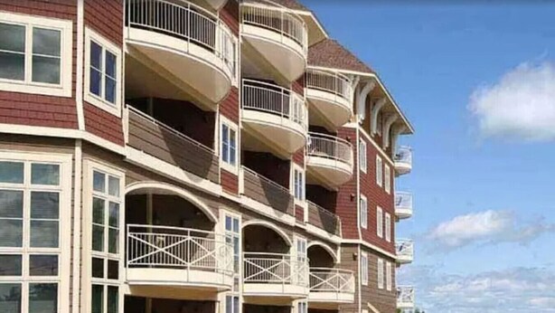 A multi-story hotel with balconies, large windows, and a view of the sea. - Beachy Condo with Pool & Hot Tub (Traverse City)
