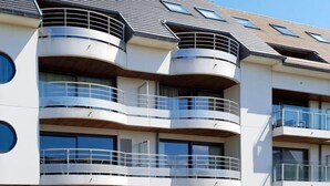 Un immeuble à plusieurs étages doté de balcons, de grandes fenêtres et d’une architecture moderne.