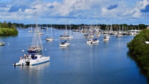 Ein Yachthafen mit zahlreichen Segelbooten, umgeben von Bäumen und blauem Himmel.