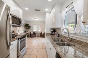 Enjoy cooking in this well-equipped kitchen with stainless steel appliances, granite countertops, and ample storage.