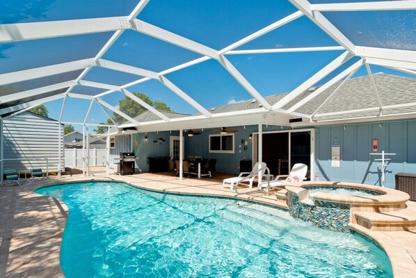 A swimming pool with a covered patio area, lounge chairs, and a hot tub. - 5 stars! ⭐️? HotTub&Pool-4BR/2BA 5 miles to beach! (Bradenton)