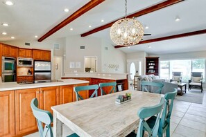 A modern kitchen with wooden cabinets, stainless steel appliances, and a central island. - 5 stars! ⭐️? HotTub&Pool-4BR/2BA 5 miles to beach! (Bradenton)