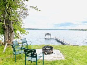 Un parc au bord du lac, doté d’un foyer, de chaises en métal vert et d’un banc qui s’avance sur l’eau.