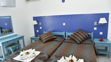 Une chambre d’hôtel avec deux lits, un bureau, une chaise et une table de chevet.