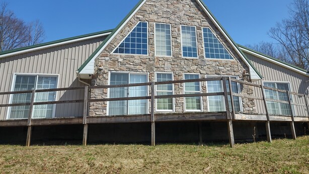 A large, stone-clad building with a prominent triangular roof and multiple windows. - Knotty Knob is your mountain get away! (Frametown)