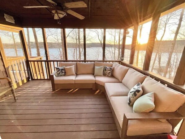 Relax on the enclosed porch with a L-shaped sofa and enjoy the serene views of the water and trees.