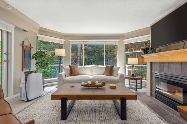 A cozy living room with a fireplace, a sofa, and a coffee table.