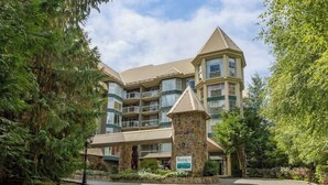 A multi-story hotel with a stone entrance and a sign reading "Woodrun." - Upper level condo w/ AC & hot tub (Whistler)