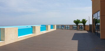 Una piscina al aire libre, sillones reclinables de piscina