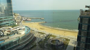 Un paisaje urbano costero con playa, muelle y edificios modernos.