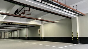 A spacious indoor parking area with multiple lanes, visible structural beams, and safety barriers. - Kotta GO Yogyakarta (Yogyakarta)