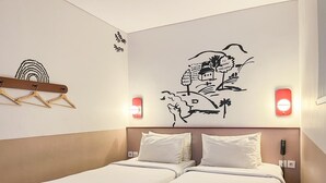 A hotel room with two beds, a wall-mounted coat rack, and a wall decal. - Kotta GO Yogyakarta (Yogyakarta)