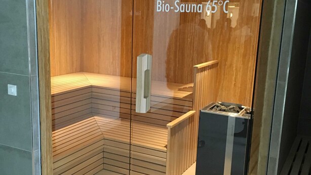 A Bio-Sauna with a temperature of 65°C, wooden interior, and glass doors.