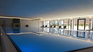 An indoor swimming pool with a clear view of the outside.