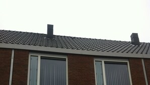 A two-story residential building with a tiled roof, brick facade, and large windows with curtains. - A castle a few km from here (Utrecht)