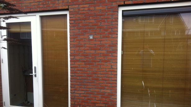 A brick building with a sliding glass door and a large window with blinds. - A castle a few km from here (Utrecht)