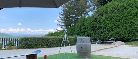 An outdoor seating area with a table, wine glasses, and a bottle.