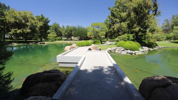 A serene park with a pond, a concrete bridge, and surrounding greenery. - Poolside Studio in Central DTPH Location w/ Pool (Phoenix)