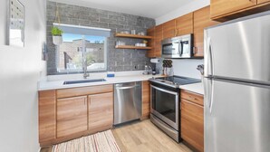 A modern kitchen with wooden cabinets, stainless steel appliances, and a stone backsplash. - DTPH Modern Designer Studio - Pool & Parking - (Phoenix)