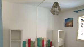 Ein Schlafzimmer mit einem Bett, einem Kleiderschrank, einer Regaleinheit und einem Bild an der Wand.
