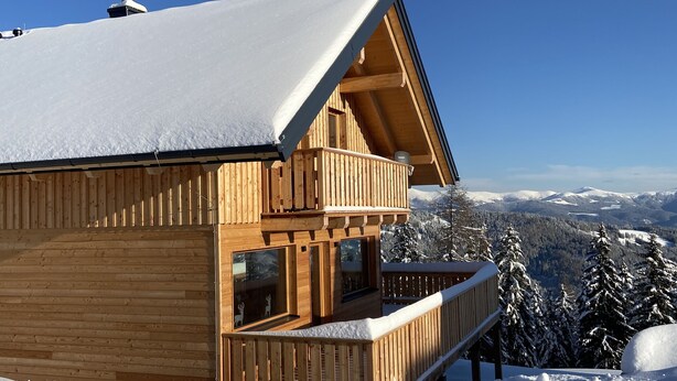 A wooden chalet with a balcony, set against a snowy mountain backdrop. - Klippitztörl - The exclusive chalet for discerning nature lovers (Bad St. Leonhard)