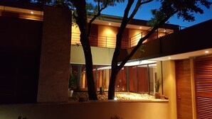 Een modern herenhuis met twee verdiepingen, een balkon, grote ramen en een goed verlichte entree.