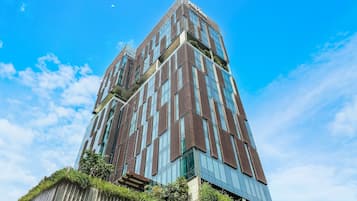 Un edificio alto y moderno con fachada de vidrio y listones verticales de madera.