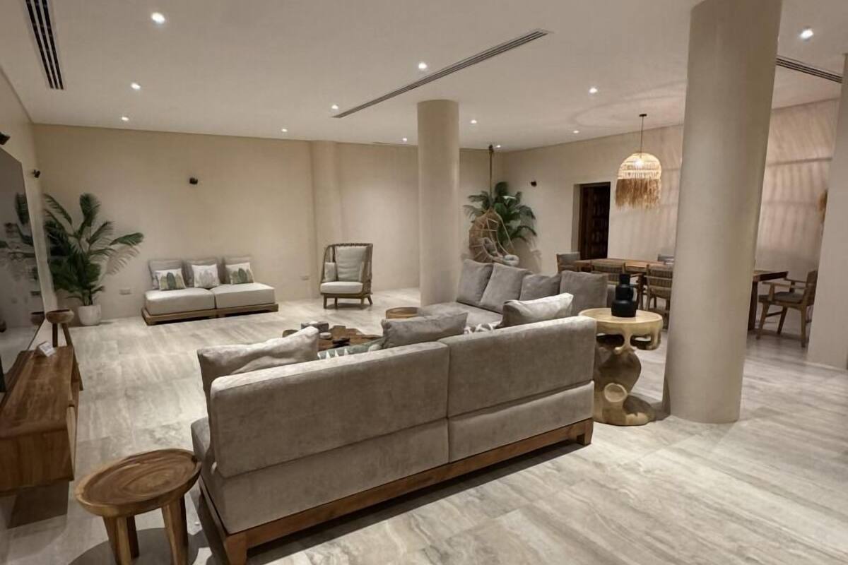 Amplia sala de estar con un sofá grande, una mesa de centro y una mesa de comedor.
