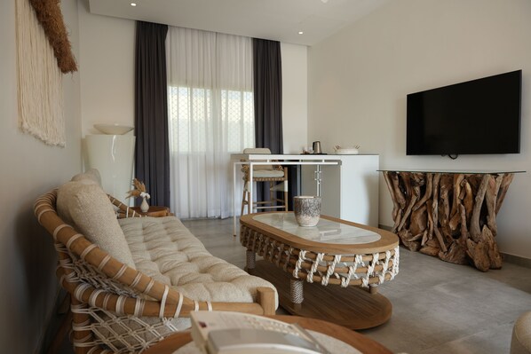 A modern living room with a sofa, a coffee table, and a TV mounted on the wall.