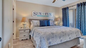 A bedroom with a bed, nightstands, a ceiling fan, and a sign that reads "SUN AND FUN". - Next to SDC, walk to Table Rock Lake (Branson)